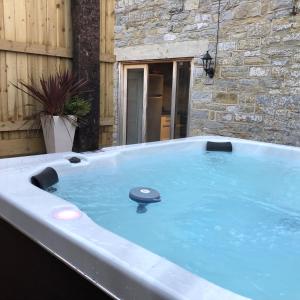 Hatch BeauchampSomerset Country Escape - Luxury barns with hot tubs的房屋后院的按摩浴缸