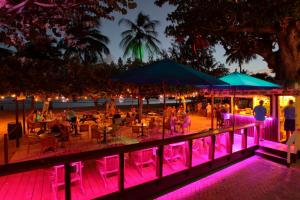 布里奇敦椰子园海滩酒店的一群人晚上坐在海滩的桌子上