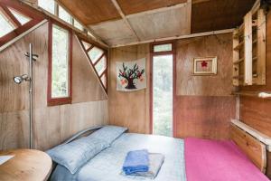 Island BayThe Treehut的一间设有床铺的卧室,位于带窗户的房间内