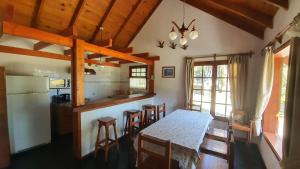 拉安戈斯图拉镇Cabañas & Aparts Lancuyen, Villa de Montaña的厨房以及带桌椅的用餐室。