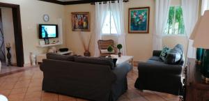 璜多里奥Villas Del Jardin 7的客厅配有两张沙发和一台电视机