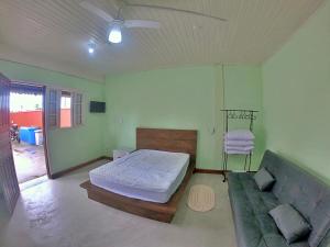 圣保罗Kitnet Com Ar, em frente a Praia de Boracéia的一间卧室配有一张床和一张沙发
