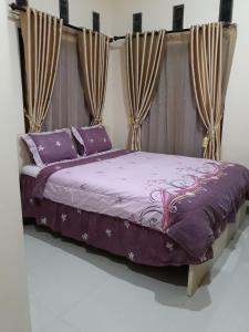 兰特包Toraja Lodge Hotel的一间卧室配有一张带窗帘的紫色床