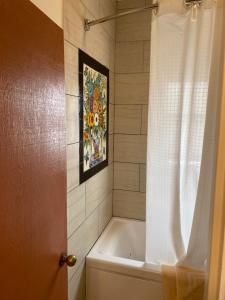 圣巴巴拉玫瑰别墅旅馆的带浴缸和淋浴帘的浴室