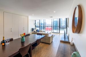 墨尔本Melbourne City Apartments - Teri的客厅配有桌子和沙发
