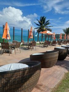 康德Tabatinga Flat - Beira Mar的海滩上的一组桌椅和遮阳伞