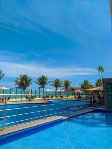 康德Tabatinga Flat - Beira Mar的一座棕榈树和遮阳伞的大型游泳池