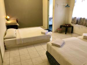 彭亨Bentong Makmur Guesthouse的酒店客房设有两张床和窗户。