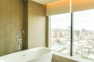台南富驿时尚酒店的带浴缸的浴室和大窗户