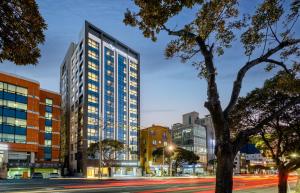 济州市Ventimo Hotel & Residence Jeju的夜幕降临的城市街道上一座高楼