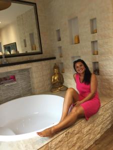 里米尼Luxury Suite的坐在浴缸边缘的女人