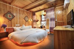 龙胜Longji Terrace La vie Inn的一间带一张大床的卧室,位于带木墙的房间