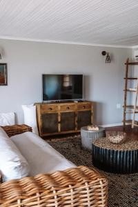 Op-die-BergBoplaas Guesthouse的带沙发和平面电视的客厅