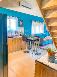 Sainte-SuzanneLe Tuit-Tuit ****的一间厨房和带蓝色墙壁及桌子的用餐室