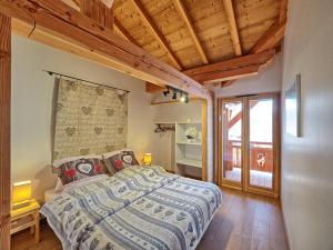 雷加霍斯达哈施Chalet Arpitan - les Carroz - Grand Massif的一间带一张床的卧室,位于带木制天花板的房间内