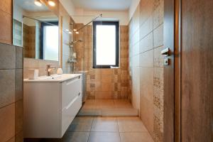 克卢日-纳波卡Nuuc Aparthotel Cluj-Napoca的浴室设有白色水槽和镜子