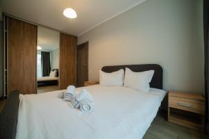 克卢日-纳波卡Nuuc Aparthotel Cluj-Napoca的卧室配有白色床和毛巾