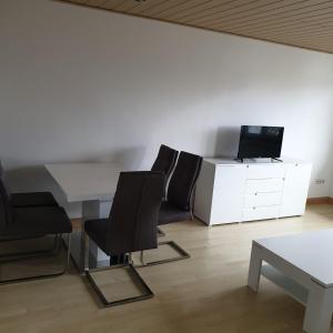 埃佩尔海姆schöne 3 Zimmer Stadtwohnung的配有桌子和两把椅子以及电视的房间
