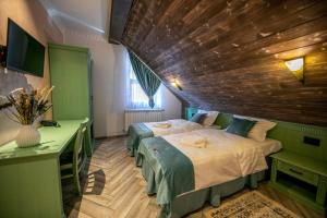 巴亚斯普列Hanul Tentea-Pasul Gutai的一间卧室设有两张床和木制天花板