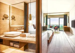 三亚三亚湾假日度假酒店的一间带水槽的酒店浴室和一间卧室