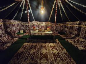 ShāhiqCrescent Desert Private Camp的圆顶帐篷的内部,圆顶帐篷内有带花瓶的桌子