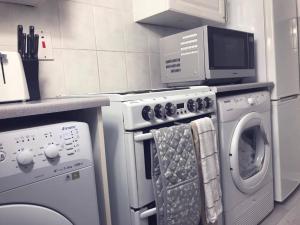 柯科迪Captivating 2-Bed Apartment in Kirkcaldy的厨房配有洗衣机和微波炉。