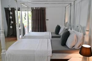 帕杰B4 BOUTIQUE的一间卧室配有两张带白色床单和枕头的床。