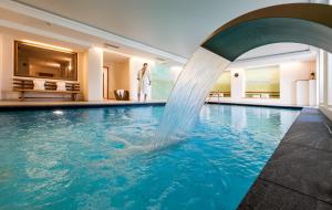 拉伊翁Hotel Überbacher的一座酒店带喷泉的游泳池