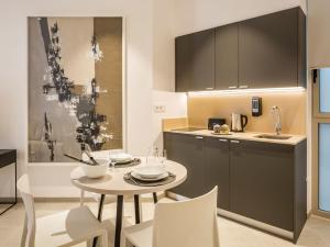 瓦伦西亚Mon Suites Benlliure的厨房配有桌椅和水槽。
