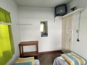 迪亚曼蒂纳Pousada Dona Dazinha的客房设有两张床和一台墙上的电视。