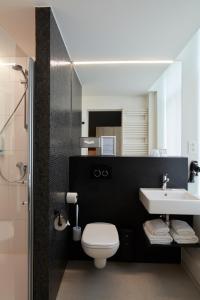 蒂嫩Alpha Hotel and Aparthotel的浴室配有白色卫生间和盥洗盆。