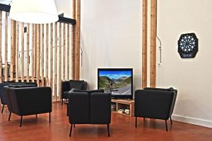 圣米歇尔德莫里耶讷马林坦酒店的一间带椅子和一张桌子上的电视的房间