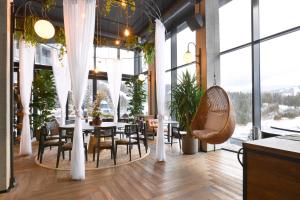 布克维Mountain Residence Apartments & Chalet的餐厅设有桌椅和大窗户。