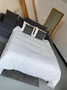 迪南À deux PATENIER de Dinant的一张带枕头和沙发的大型白色床