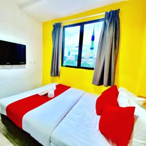 汝来Hotel Aman- Nilai & KLIA的一间卧室配有一张带红色枕头的大床和窗户