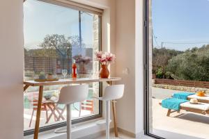 瓦莫斯Canna Villa的一间带桌子和大窗户的用餐室