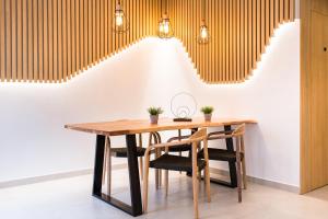 休达德亚Sagitario Petit Ciutadella的一间带木桌和椅子的用餐室