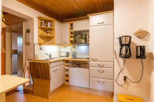 埃恩鲁赫Ferienwohnung-Mediterran的厨房配有白色橱柜和冰箱。