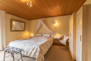 埃恩鲁赫Ferienwohnung-Mediterran的一间卧室设有一张木天花板床。