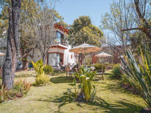 圣克里斯托瓦尔-德拉斯卡萨斯Hotel Casa de Familia de San Cristobal的房屋前带椅子和遮阳伞的花园