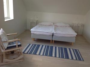 拉霍尔姆Ny Flintarp的一间设有两张床、椅子和地毯的房间