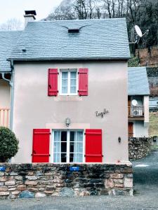 热德尔ZAGALA LA MAISON DE LA MONTAGNE的白色的房子,有红色百叶窗和石墙
