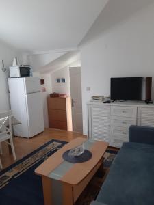 蒂瓦特Apartmani Stipanic Tivat的客厅配有桌子和白色冰箱。