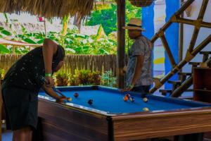 帕洛米诺Primaluna Beach Hostel的两个男人在台球桌打台球