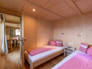 布里克森谷地霍普夫加尔滕Biobauernhof Fleckl的一间带两张床铺的卧室,位于带木墙的房间内