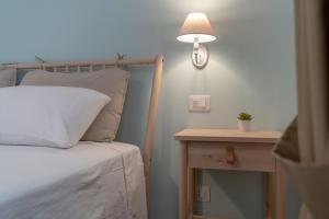 瓦斯托Natura e Mente Camere e Relax的一间卧室配有一张床和一张带台灯的桌子