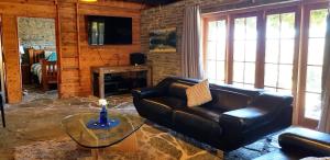 箭镇Creagh Cottage and Homestead的客厅配有真皮沙发和玻璃桌