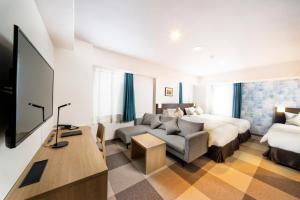 札幌KOKO HOTEL Sapporo Odori的酒店客房,配有床和沙发