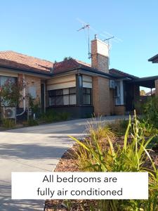墨尔本Sunny House - Melbourne Airport Home的房屋配有标牌,所有卧室均配有空调。
