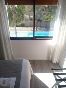 维拉卡洛斯帕兹Casa Piedra Hotel的卧室设有窗户,享有游泳池的景色